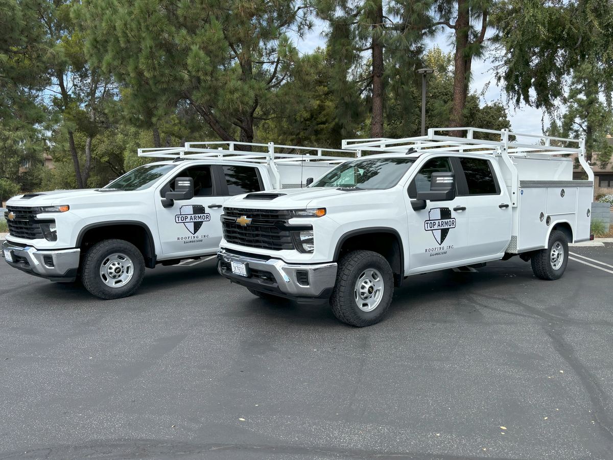 Two Top Armor service trucks with the shield logo and license number